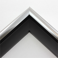 This medium radius stainless steel canvas floater frame has a rounded U-shaped face. The weighted face is metallic white-silver and reflects dispersed light.